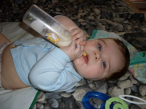 кормление ребенка из бутылочки в кроватке. бутылочки для детей. когда ребенок держит бутылочку. во сколько месяцев ребенок сам держит бутылочку. малыш с бутылочкой.